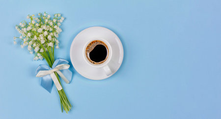 a Cup of black coffee on a saucer and a bouquet flowers lily of the valley on a blue background with...