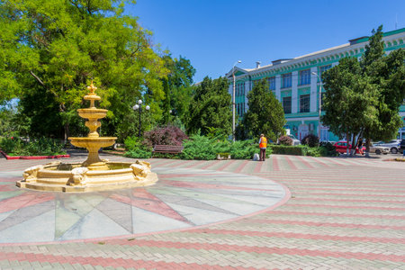 Kerch, Russia - 13 August 2019: a janitor removes garbage on the square with a fountain on a summer dayのeditorial素材