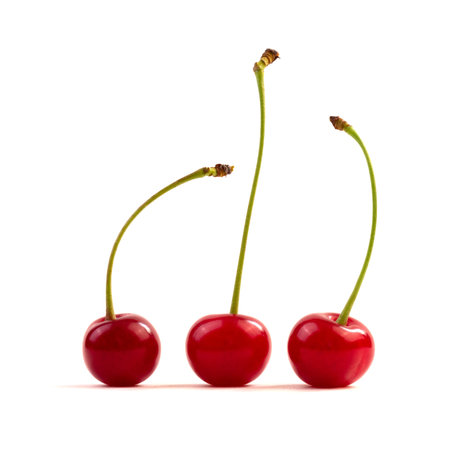 three red ripe cherries isolated on a white background