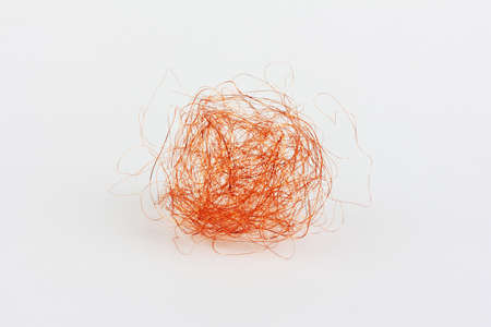 a crumpled coil of copper wire on a white backgroundの写真素材