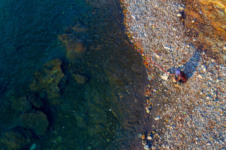 young man fishing in the river on an autumn day, top viewの写真素材