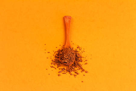 wooden spoon with instant granulated coffee on a background yellow colorの写真素材
