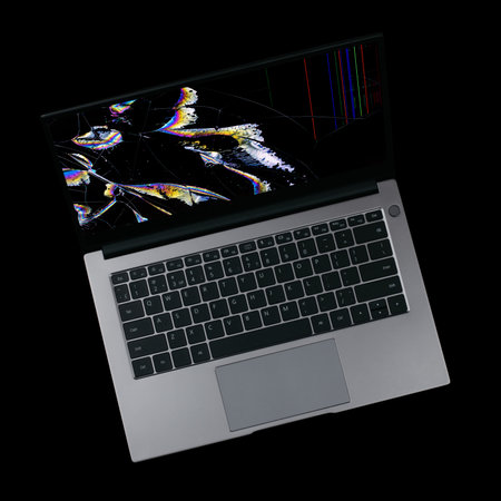 laptop with a broken screen with color glitches isolated on a black background close upの写真素材