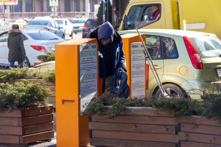 Krasnodar, Russia - December 17, 2020: a male employee of the municipal service removes garbage from...