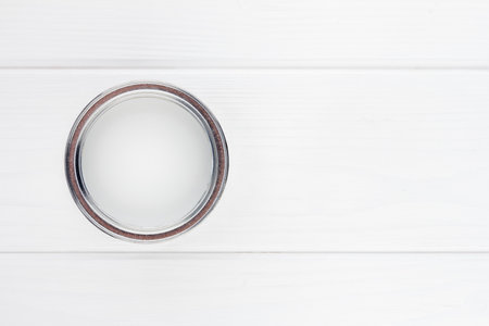 open can with white paint on a white wooden background top view with copy spaceの写真素材