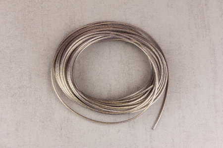 metal polymer cable in a skein on a gray background top view close-up