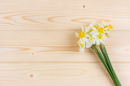 bouquet of white narcissus flowers on a wooden background with a copy spaceの写真素材