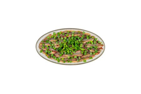 fillet of salted fish European anchovy with green onions and parsley in an oval glass plate isolated on a white background top view with clipping pathの写真素材