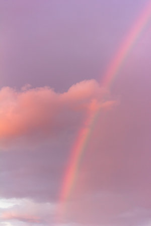 landscape with rainbow and pink cloud on cloudy evening skyの写真素材