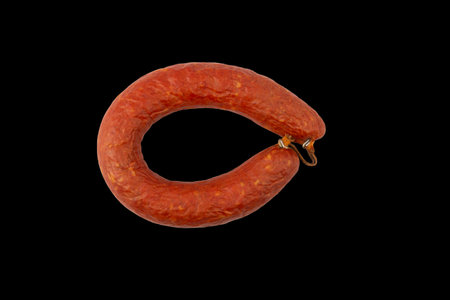 ring of semi-smoked sausage isolated on a black background top viewの写真素材