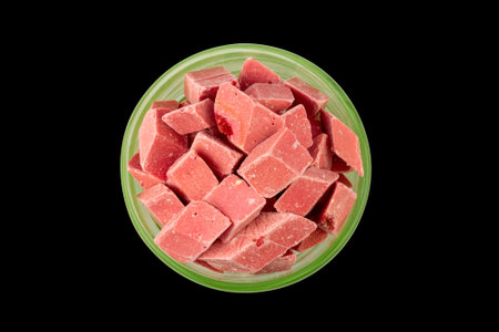 pink pieces of Uzbek dairy strawberry halva in a green bowl isolated on a black background top viewの写真素材