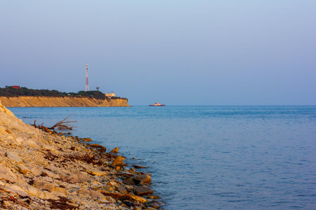the seashore and a boat on the horizon on a summer eveningの写真素材