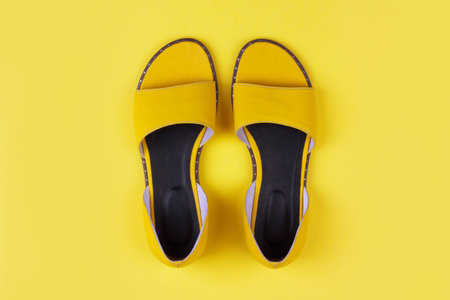 yellow female summer sandals on a yellow background top viewの写真素材