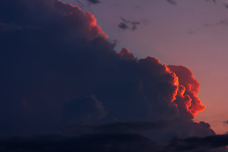 landscape with dark and red clouds in the evening sky in the rays of the setting sunの写真素材