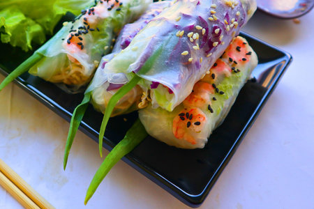 Fresh Vietnamese spring rolls filled with shrimp, crisp vegetables, and vermicelli noodles,...