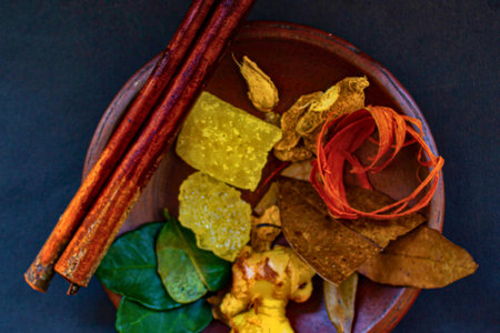 A top-down view of a rustic bowl filled with a vibrant mix of dried botanicals, spices, and colorful dried fruit slices.の写真素材