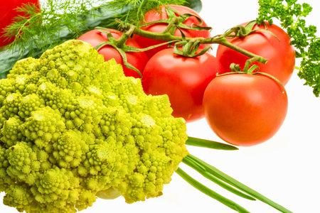 A vibrant close-up of Romanesco broccoli, ripe tomatoes, and fresh green herbs on a white background.の写真素材