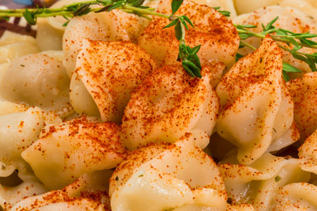A close-up shot of roasted potato wedges seasoned with paprika and fresh herbs, ready to be served.の写真素材