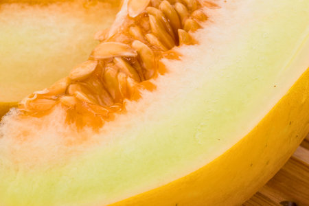 A detailed macro view of the juicy, orange flesh and fibrous seed cavity of a ripe cantaloupe.の写真素材