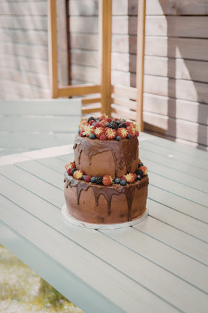 A delicious two-tiered chocolate cake with chocolate ganache dripping down the sides, topped with an...