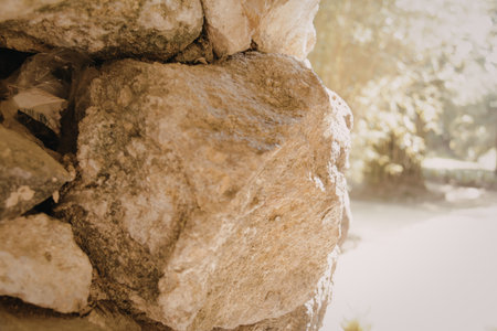 A detailed close-up of stacked rocks in a natural outdoor setting, with greenery in the background.