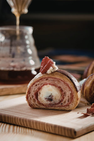 A close-up image of a delectable pastry featuring a cream filling and topped with a fresh...