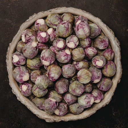 A close-up image of fresh Brussels sprouts displayed in a rustic basket against a dark background. The Brussels sprouts are vibrant with a mix of green and purple hues.の写真素材