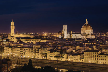 A captivating night view of Florence, Italy, showcasing its iconic landmarks illuminated against the dark sky. The image highlights the city's architectural beauty, with prominent buildings and the famous dome of the Florence Cathedral standing out.の写真素材