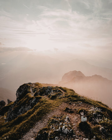 A serene image of a mountain trail winding through rugged terrain, with a group of hikers making...