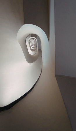 A close-up view of a sleek, white staircase with a unique, minimalist design. The staircase curves...