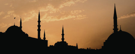 A captivating image of mosque silhouettes against a vibrant sunset sky, showcasing the beauty of...