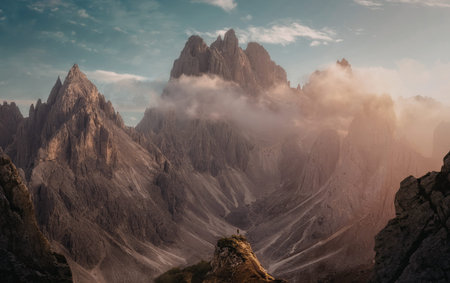 A breathtaking landscape showcasing towering mountain peaks bathed in golden sunlight, with clouds...