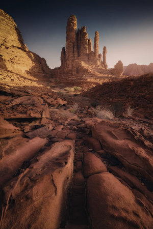 A breathtaking view of Monument Valley at sunset, showcasing towering rock formations and rugged terrain under a clear sky.の写真素材