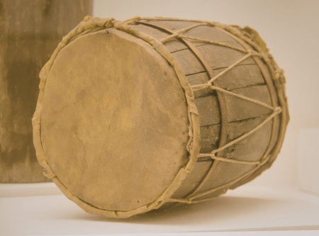 A close-up view of a traditional handcrafted drum, showcasing its natural materials and intricate...