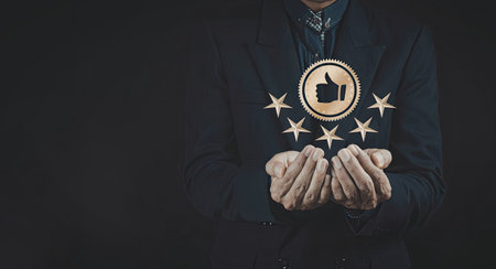 A businessman in a suit is holding a digital coin with a thumbs-up symbol, surrounded by stars. The...
