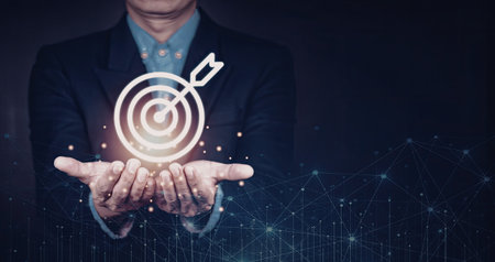 A businessman in a suit is holding a digital target symbol in his hands, representing focus and achievement in a professional setting.の写真素材