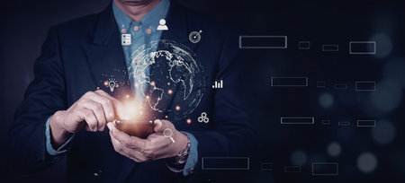 A businessman in a suit is interacting with a digital globe, symbolizing global business and...
