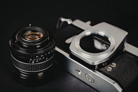 A close-up photograph of a vintage camera lens and body placed side by side, showcasing their intricate details and classic design.の写真素材