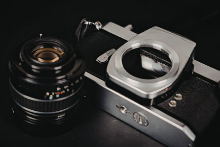 A close-up view of a camera lens attached to the body of a camera, showcasing the lens mount and...