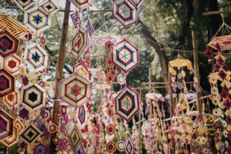 A vibrant display of hexagonal wind spinners hanging in a lush garden, showcasing a variety of colors and patterns.の写真素材