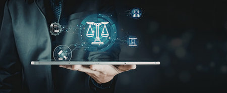 A person holding a tablet displaying a digital scale of justice surrounded by various technological icons, representing the intersection of law and modern technology.の写真素材