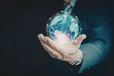 A person in a suit holding a glowing digital globe, symbolizing global connectivity and technology.の写真素材