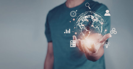 A person holding a glowing globe surrounded by various technology icons, representing global...