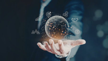 A hand holding a digital globe with various technology icons floating around it, symbolizing global...