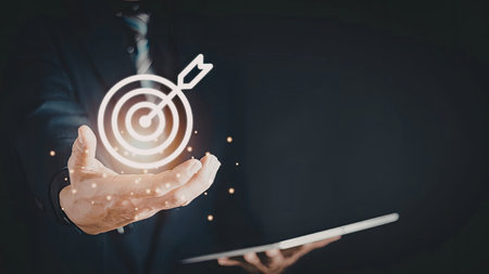 An image depicting a hand holding a digital target with an arrow, symbolizing focus and precision....