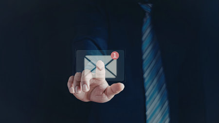 A close-up image of a hand holding a virtual envelope with a red notification badge. The hand...