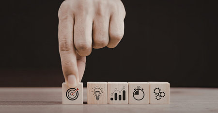 An image of a hand pointing at a set of wooden blocks, each featuring different symbols representing...