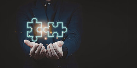 A person is holding a glowing puzzle piece in their hands, symbolizing connection, problem-solving,...