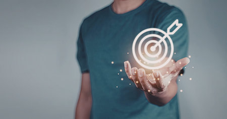 An individual wearing a blue t-shirt with a digital target symbol projected over their hands,...