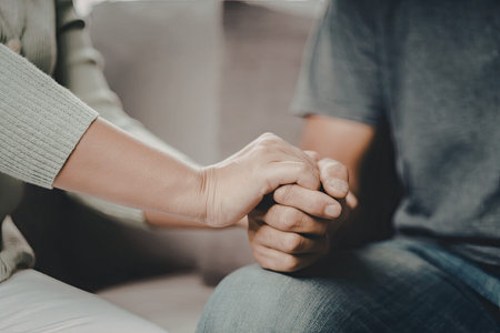 An image depicting two hands holding each other, conveying a sense of support, comfort, and...